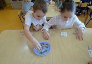 Dzieci układają spinacze zgodnie z kodem zapisanym na indywidualnej karcie.